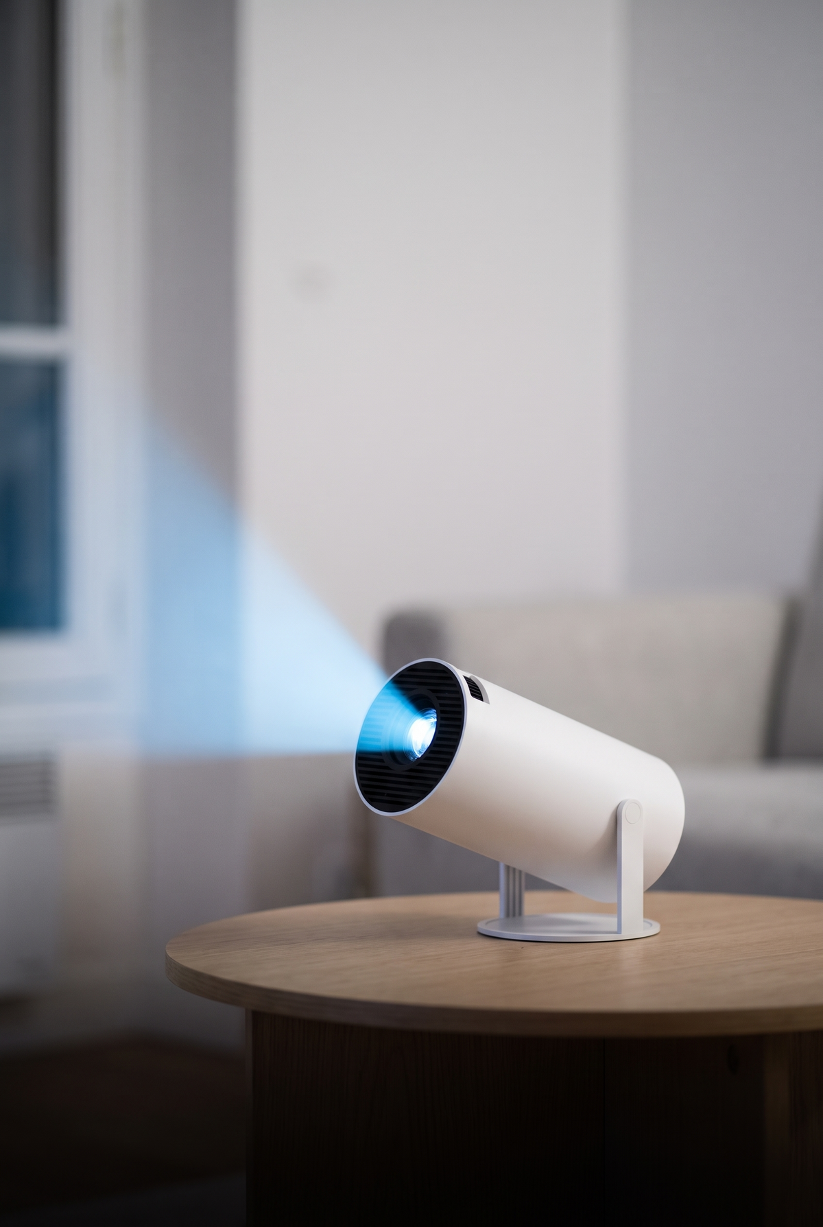 Vidéoprojecteur portable posé sur une table basse, faisceau bleu vers le mur