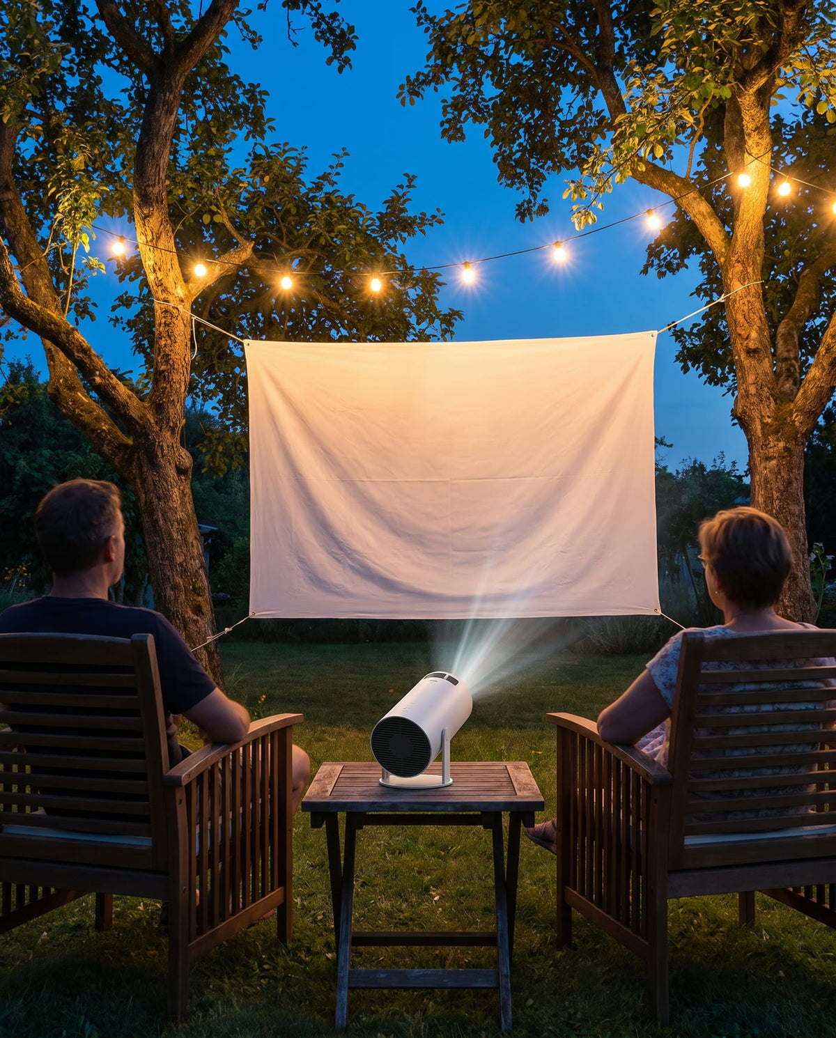 Film projeté sur un drap tendu entre deux arbres dans un jardin, le soir